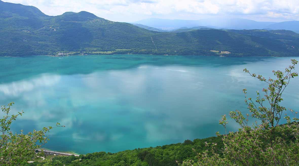 blue waters of a big lake surrounded by green mountains